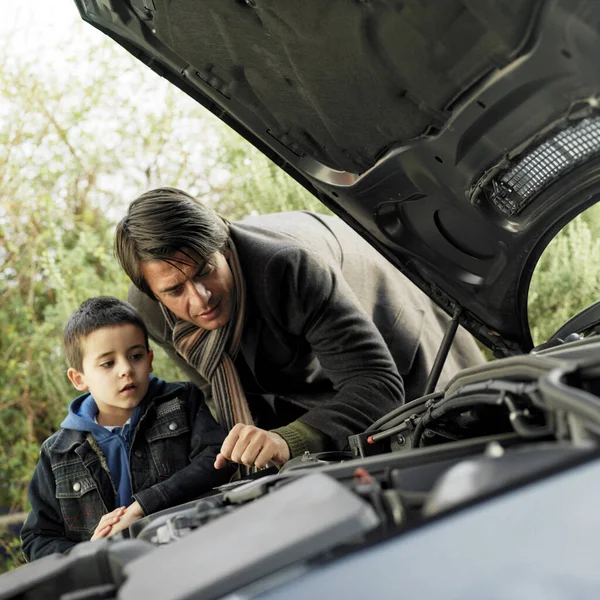 Father and son checking the condition of their car