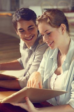 Kadın ve erkek restoranda menü okuyor.