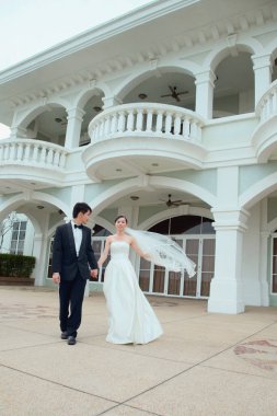 Gelin ve damat el ele tutuşup binadan çıkıyor.