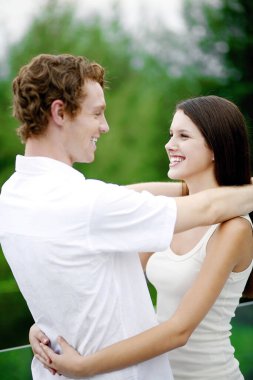 Birbirlerine sarılırken gülümseyen çiftler.