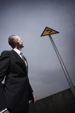 İşadamı yol tabelasına bakıyor