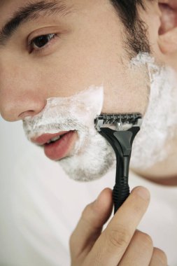 Genç adam tıraş oluyor.
