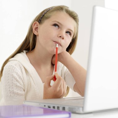 Kız bilgisayarı kullanırken düşünüyor