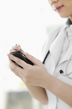 Avuç içi bilgisayarı kullanan kadın doktor