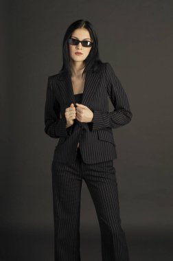 Ofiste güneş gözlüğü takan bir bayanın stüdyo fotoğrafı.