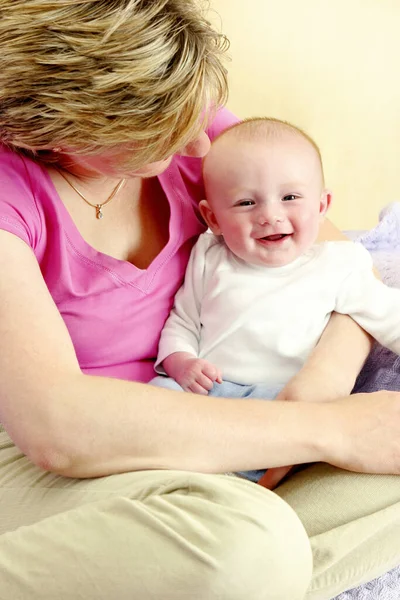 母親の膝の上で幸せそうに笑っている男の子 — ストック写真