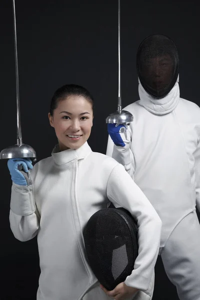 Man and woman in fencing suits posing for the camera