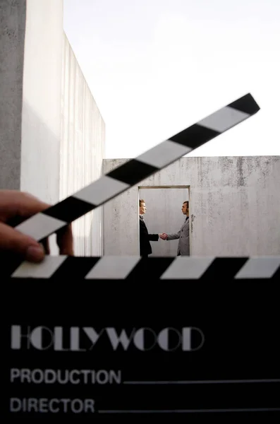 Movie Director Holding Clapboard Businessmen Shaking Hands Background — Stock Photo, Image