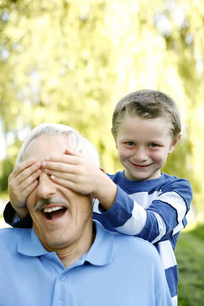 Młody Chłopiec Zakrywający Oczy Dziadka — Zdjęcie stockowe