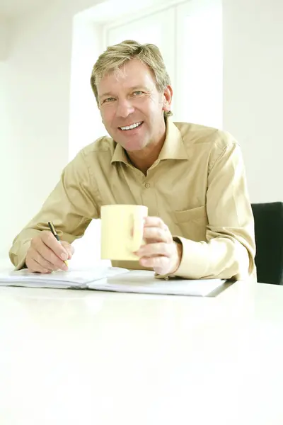 Empresario Sosteniendo Una Taza Mientras Escribe Libro — Foto de Stock