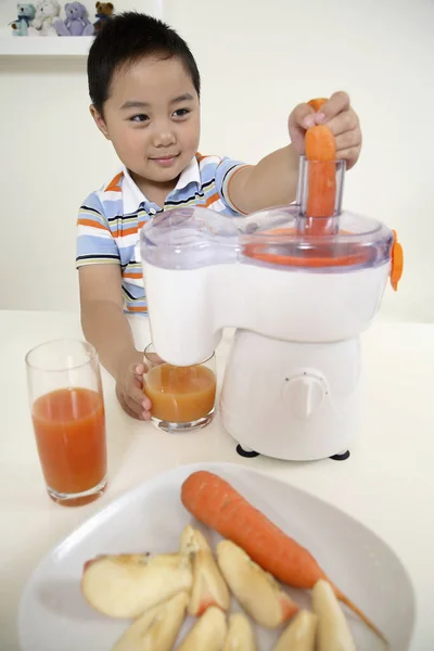 Menino Colocando Cenouras Espremedor — Fotografia de Stock