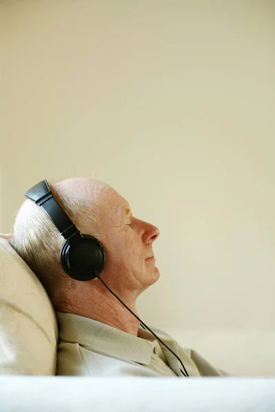 Hombre Mayor Sentado Sofá Escuchando Música Los Auriculares —  Fotos de Stock