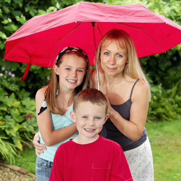 Frau Mit Schirm Schirmt Jungen Und Mädchen — Stockfoto