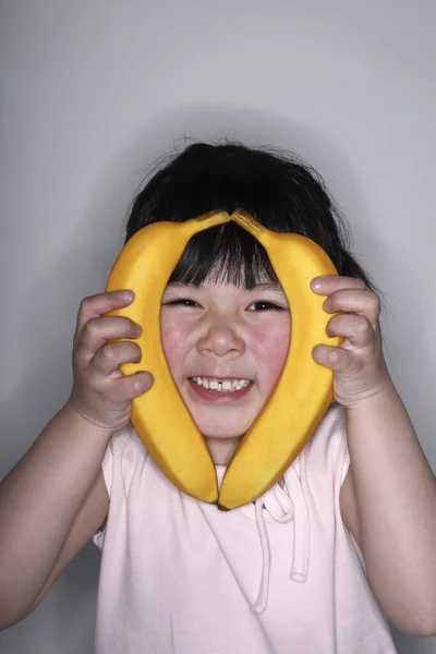 Dívka Držící Banány Stranách Tváří — Stock fotografie