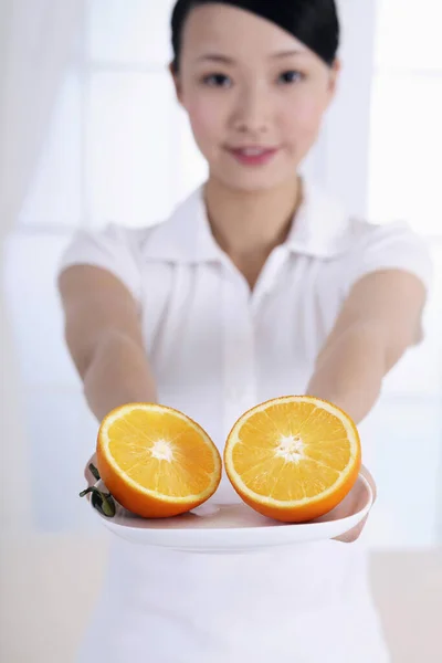 Vrouw Met Een Bord Halve Sinaasappelen — Stockfoto