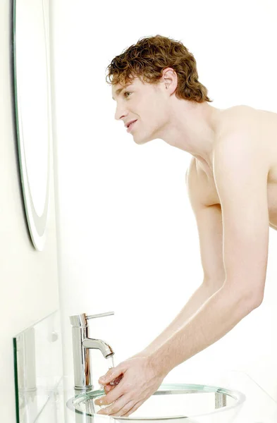浴室で顔を洗う男 — ストック写真