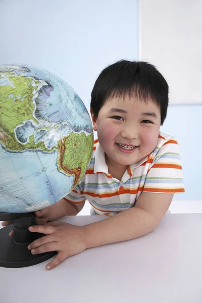 男孩笑着抱着地球仪 — 图库照片