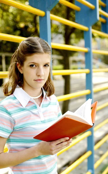 Nastolatka Patrząc Aparat Trzymając Książkę — Zdjęcie stockowe