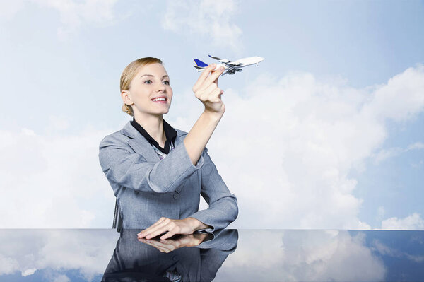 Бизнесвумен держит игрушечный самолет