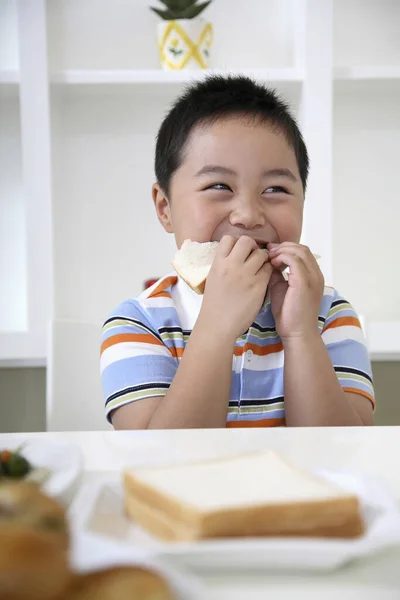 Boy smiling while eating bread