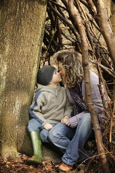 Mother and son kissing near a tree