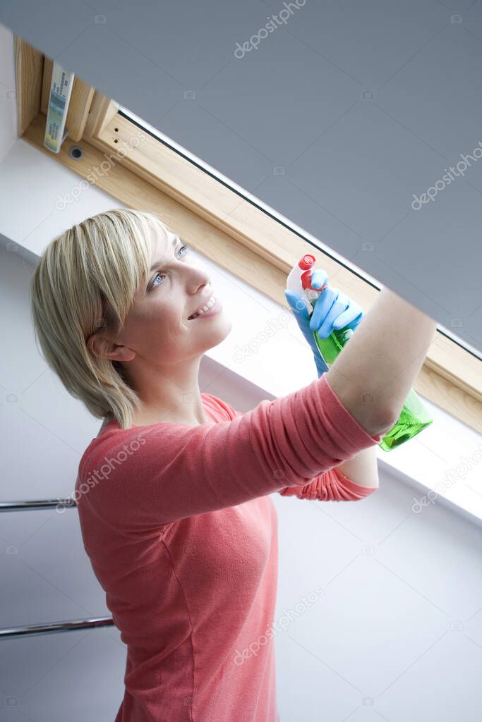 Woman wiping the attic window