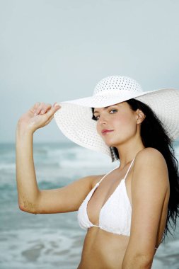 Bikini giyen ve kameraya poz veren bir kadın.