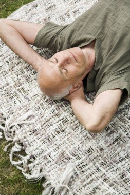 Kıdemli adam parkta kestiriyor.