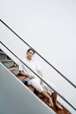 Merdivenlerde oturan adam.