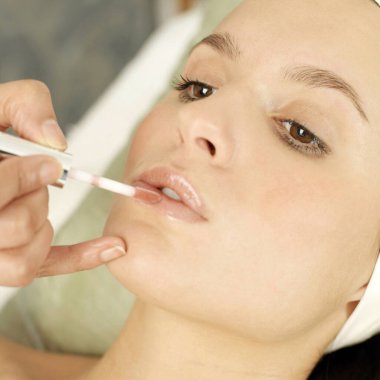 Kadının dudaklarına el parlatıcısı sürüyorum.