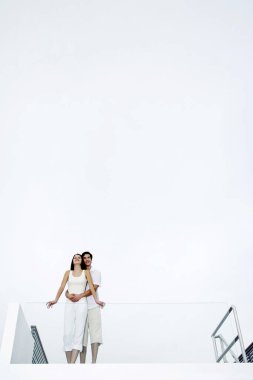 Çift balkondan manzaranın keyfini çıkarıyor.