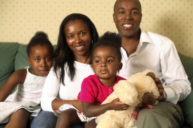 Aile kanepede oturup kameraya poz veriyor.