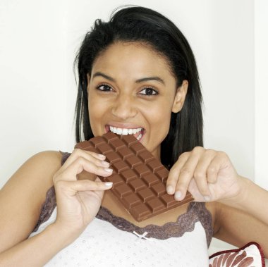 Woman enjoying a bar of chocolate clipart