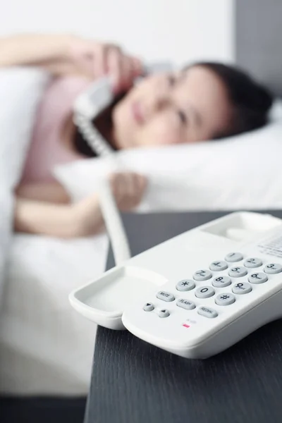 Frau Legt Sich Beim Telefonieren Auf Das Bett Und Konzentriert — Stockfoto