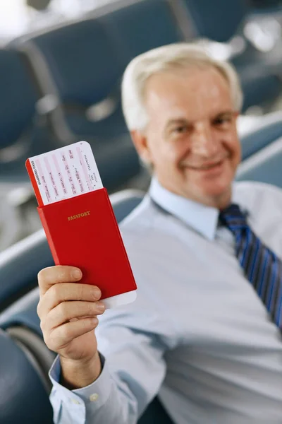 商人坐在机场休息室里 拿着护照 — 图库照片