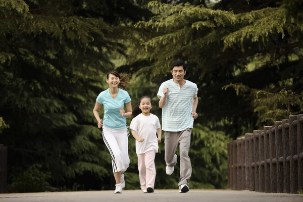 Κορίτσι Και Γονείς Τρέχουν Στο Πάρκο — Φωτογραφία Αρχείου
