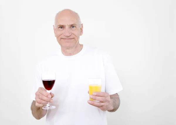 Senior Man Met Een Glas Wijn Ene Hand Sinaasappelsap Andere — Stockfoto