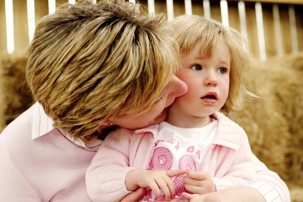 Een Vrouw Die Haar Jonge Dochter Kust Die Haar Schoot — Stockfoto