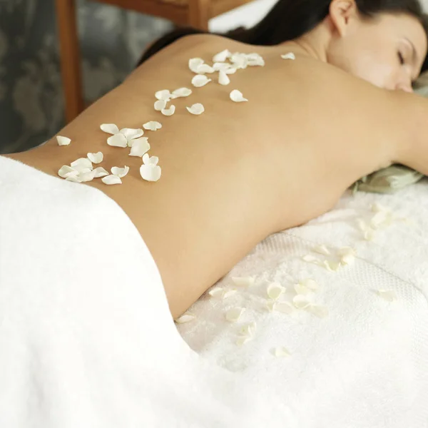Woman Lying Massage Table Rose Petals Her Back — Stock Photo, Image
