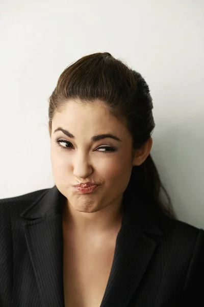 Businesswoman making a face while thinking