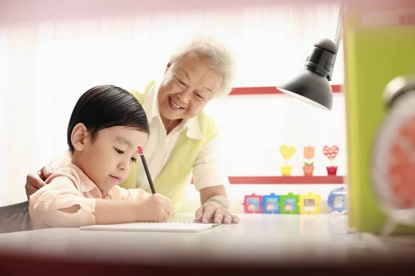 Starší Žena Pomáhá Chlapec Domácím Úkolem — Stock fotografie