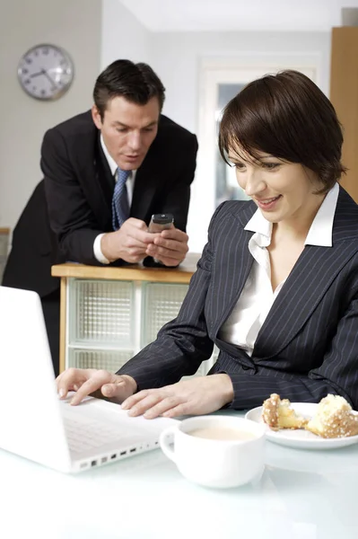 Businesswoman Using Laptop Her Husband Text Messaging Background — Stock Photo, Image