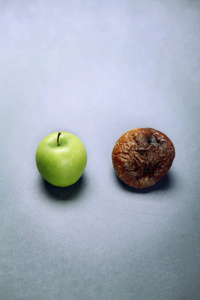 Fresh green apple and a rotten apple