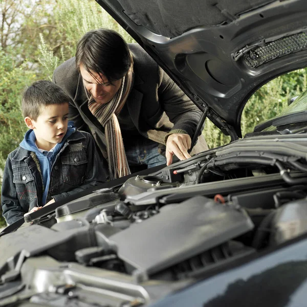 Father and son checking the condition of their car