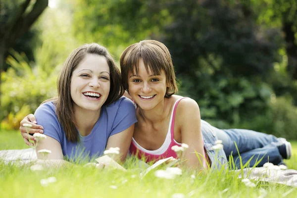 Adolescentes Tumbadas Campo Compartiendo Libro — Foto de Stock