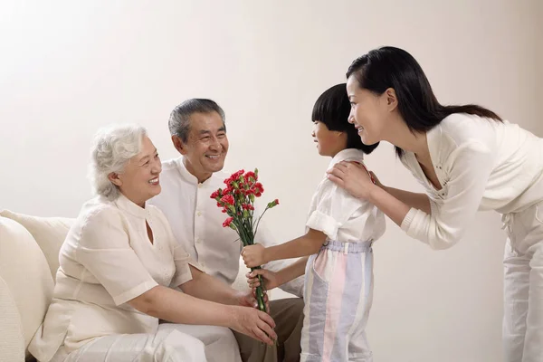Anak Laki Laki Memberikan Karangan Bunga Untuk Wanita Senior Wanita — Stok Foto