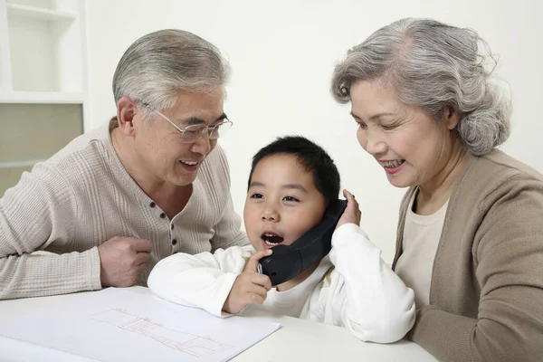 Jongen Aan Telefoon Senioren Kijken Toe — Stockfoto