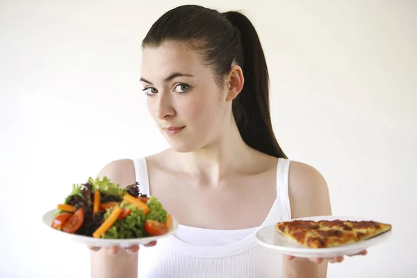 Woman holding pizza and salad