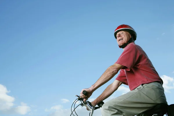 自転車に乗るヘルメットを持つシニア男 — ストック写真
