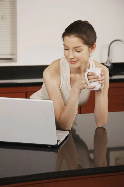 Kobieta Trzyma Filiżankę Podczas Korzystania Laptopa — Zdjęcie stockowe